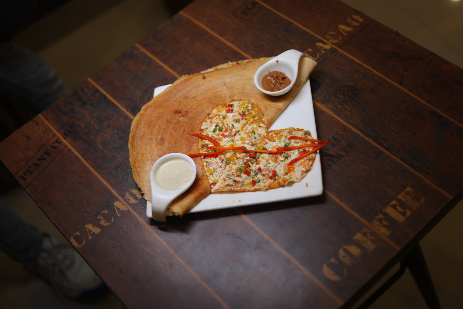 Dil Khush heart-shaped dosa on a wooden table
